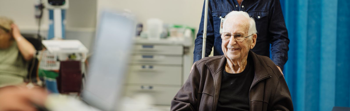 Patient in a wheelchair coming to hospital with his carer